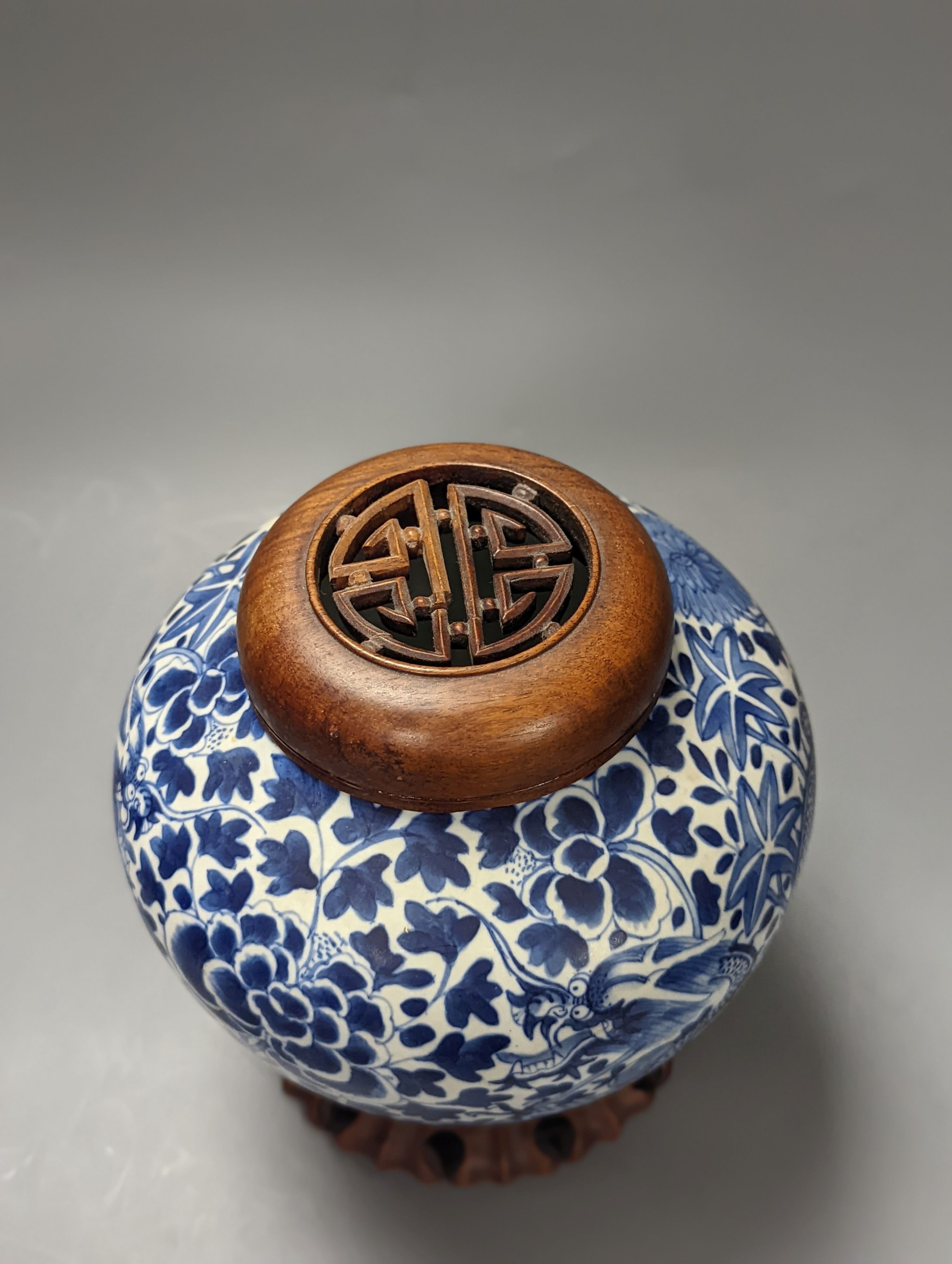 A Chinese blue and white ‘dragon’ jar, hardwood cover & stand, Qianlong mark but 19th century 22cm